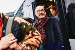 older man walking out of a train