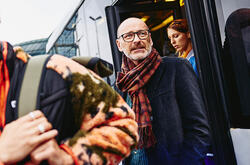 older man walking out of a train