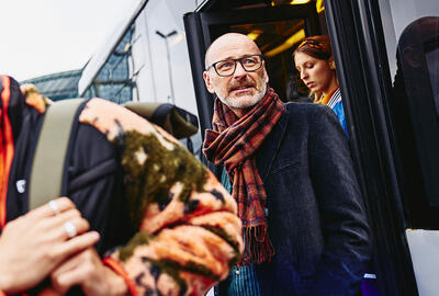 older man walking out of a train