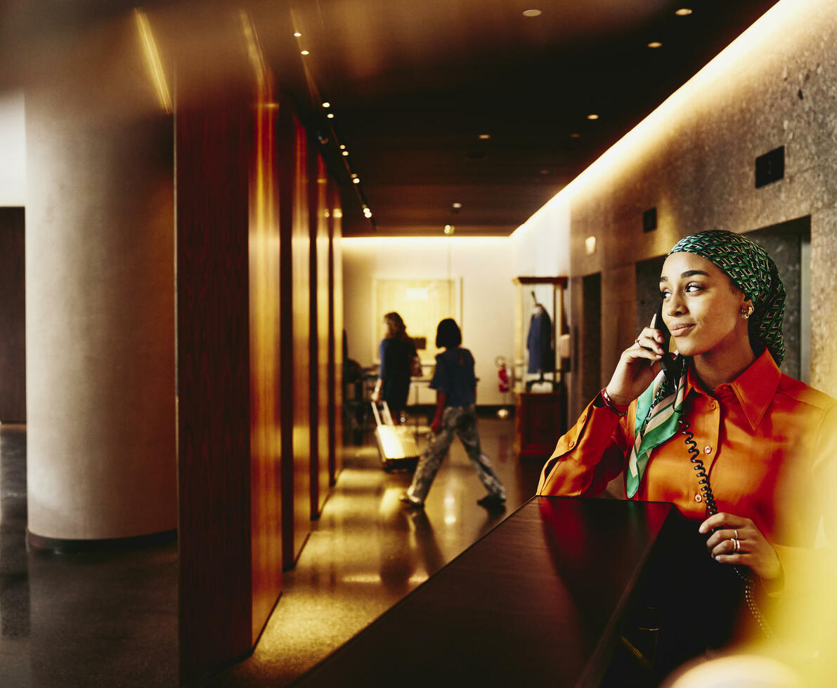 Hotel receptionist answering the phone. 
