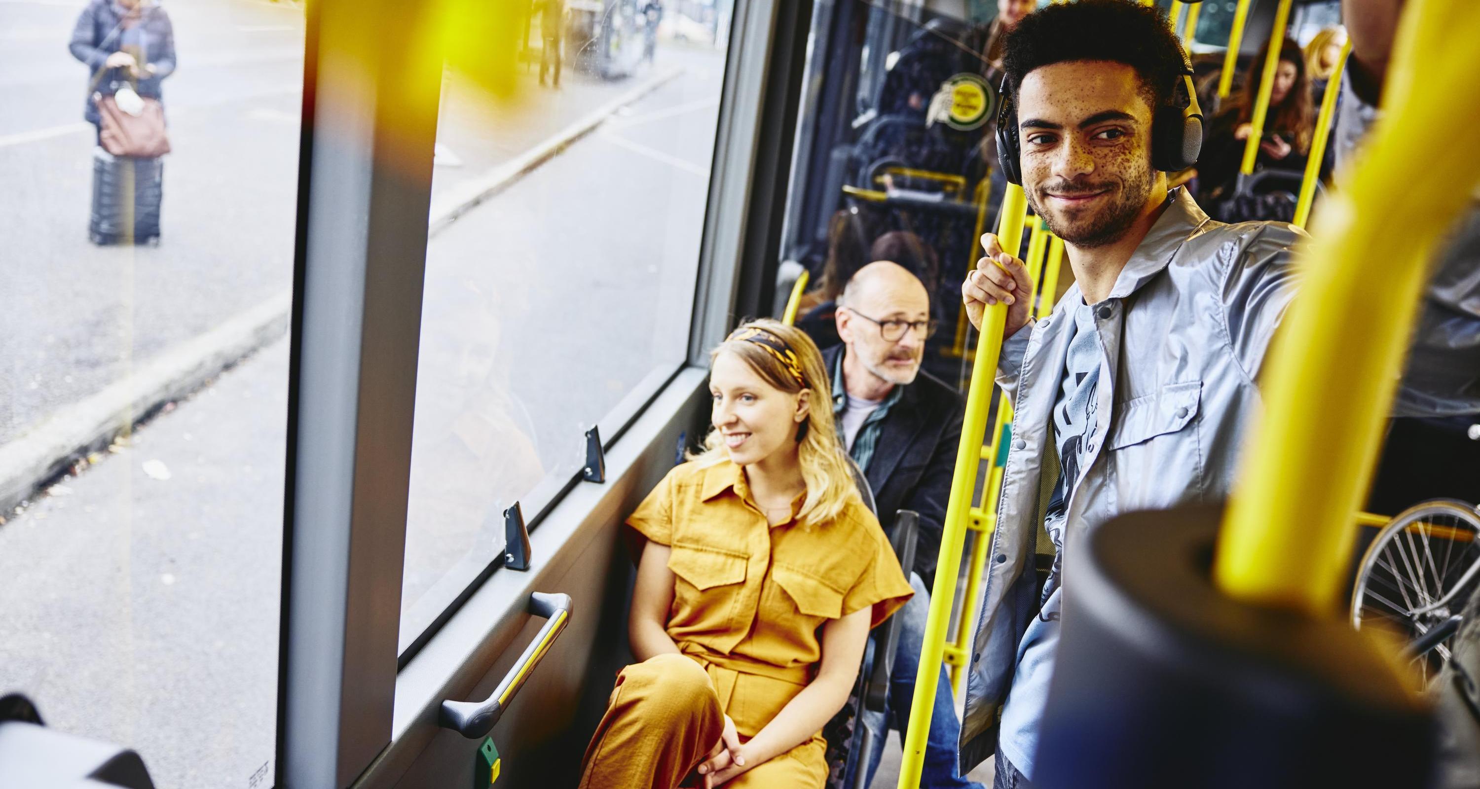 Smiling people looking outside from the bus.