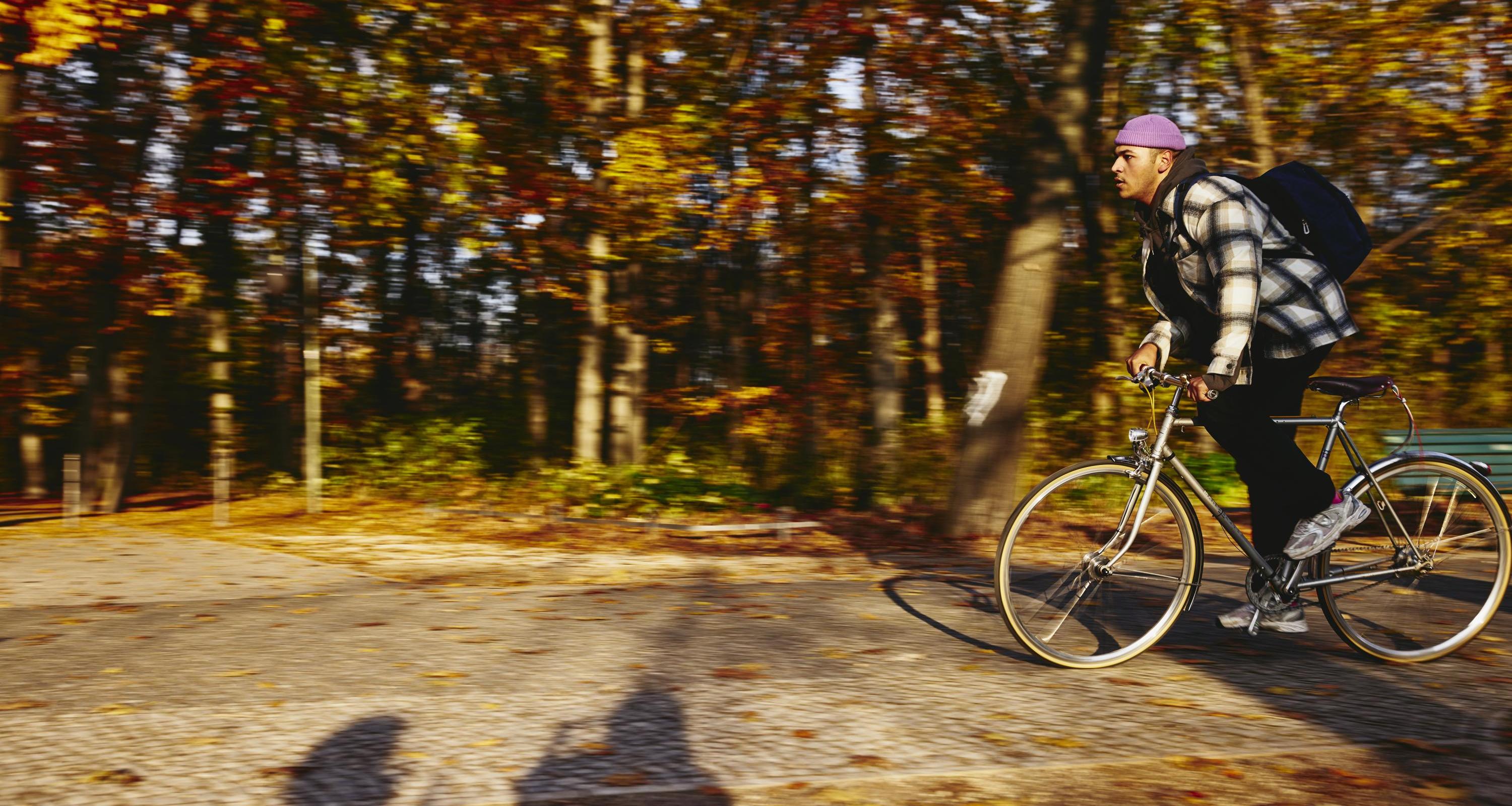 Cycling man, autumn trees on the background.