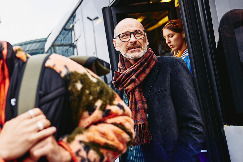 older man walking out of a train